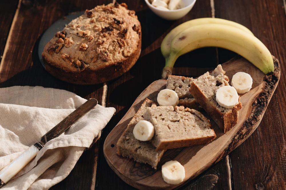 Frisch gebackenes Bananenbrot mit Bananenscheiben auf einem Holzbrett