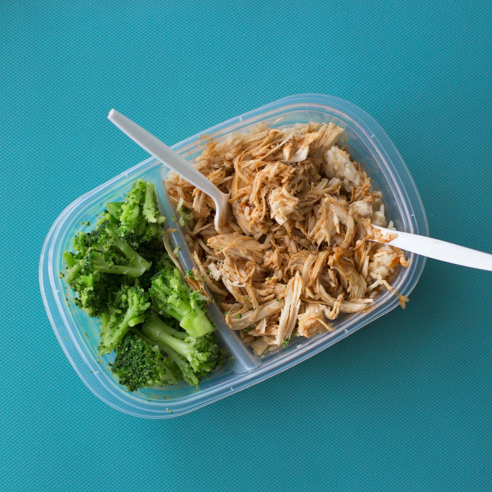 Mahlzeit in einer Plastik-Tupperware - Poulet, Reis und Broccoli